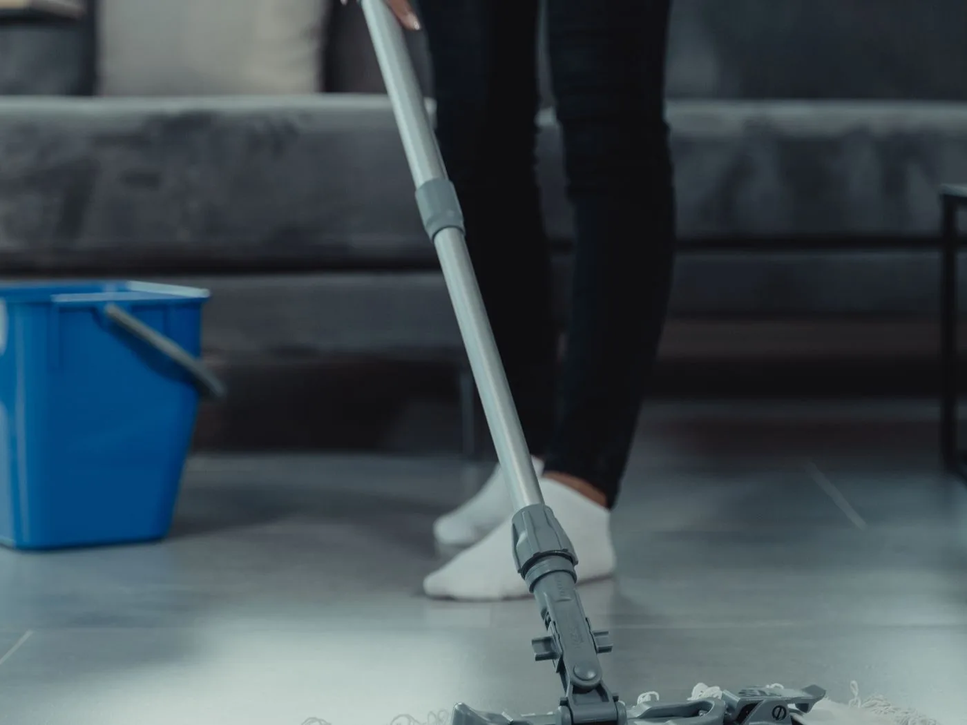 A Sweeply cleaner mopping a tiled floor